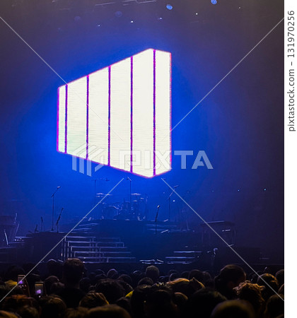 Audience in front of a stage before the start of a music concert .Blue lights on the stage in the background 131970256