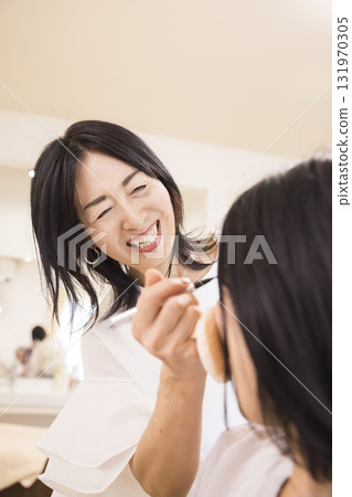 一位中年女化妝師為年輕女子化妝 131970305