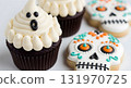 Halloween cupcakes and decorated sugar skull cookies on white background. 131970725