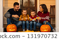 Happy family carving pumpkins together on the porch for Halloween 131970732