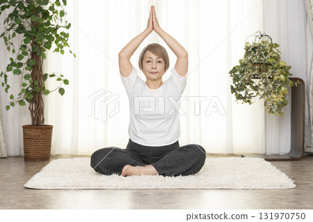 Senior woman doing Pilates in the living room 131970750