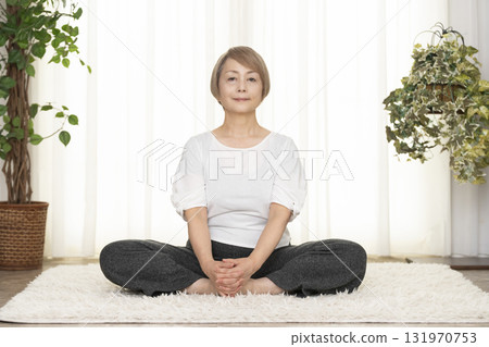 在客廳練習普拉提的老年婦女 在客廳練習普拉提的老年婦女 131970753