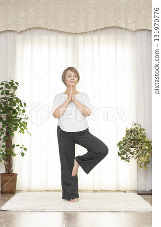 Senior woman doing Pilates in the living room Senior woman doing Pilates in the living room 131970776