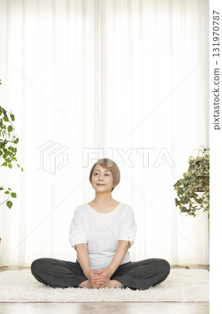 在客廳練習普拉提的老年婦女 在客廳練習普拉提的老年婦女 131970787