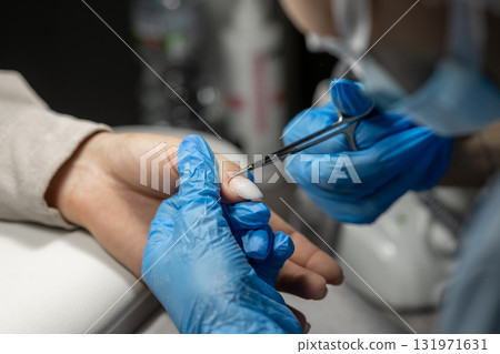 A skilled nail technician expertly shapes and cares for a clients nails in a well lit beauty salon environment. A skilled nail technician expertly shapes and cares for a clients nails in a well lit beauty salon environment. 131971631