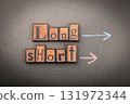 Long and Short with wooden block letters on chalkboard and arrows drawn in chalk 131972344