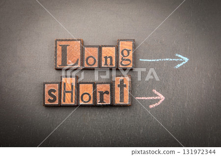 Long and Short with wooden block letters on chalkboard and arrows drawn in chalk Long and Short with wooden block letters on chalkboard and arrows drawn in chalk 131972344