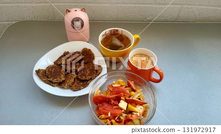 Breakfast with healthy pancakes, fresh salad, and herbal tea on a light gray table Breakfast with healthy pancakes, fresh salad, and herbal tea on a light gray table 131972917