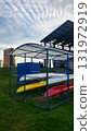 Kayaks stored under cover at a water sports center near a residential area on an overcast day 131972919