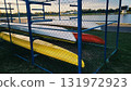 Colorful kayaks stored on racks by a calm lake during a sunny afternoon in late summer 131972923