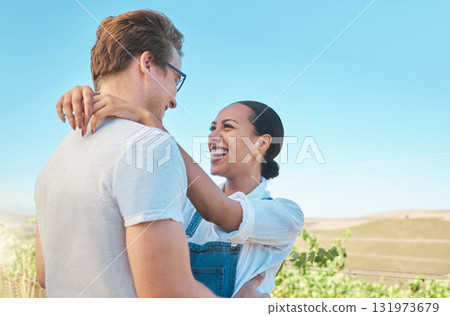 Laughing, in love and happy interracial couple in hug, embrace or holding each other on wine tasting farm. Fun, playful or loving man and woman standing close and enjoying countryside vineyard estate 131973679