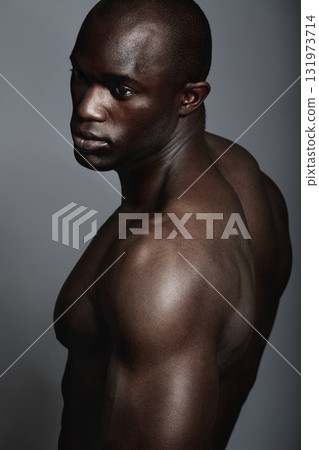 Art, aesthetic and beauty, black man on dark background with muscle and fitness, strong and serious body builder. Health, wellness and African bodybuilder or male model isolated on studio backdrop. Art, aesthetic and beauty, black man on dark background with muscle and fitness, strong and serious body builder. Health, wellness and African bodybuilder or male model isolated on studio backdrop. 131973714