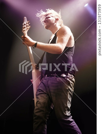 Music, festival and man with guitar on a stage for performance, passion or artistic freedom. Rock, concert and guy musician on electric musical instrument, night or rockstar event in metal aesthetic 131973959