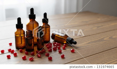 Pomegranate seed oil in amber dropper bottles for natural skincare. Cosmetic serum with organic ingredients for beauty and wellness. Mockup on a wooden table with copy space Pomegranate seed oil in amber dropper bottles for natural skincare. Cosmetic serum with organic ingredients for beauty and wellness. Mockup on a wooden table with copy space 131974665