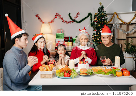 Celebrate Christmas with family in a cozy, festive setting. Santa hats, gifts, and delicious food capture the warmth, jo 131975260