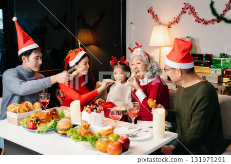 Celebrate Christmas with family in a cozy, festive setting. Santa hats, gifts, and delicious food capture the warmth, jo Celebrate Christmas with family in a cozy, festive setting. Santa hats, gifts, and delicious food capture the warmth, jo 131975291