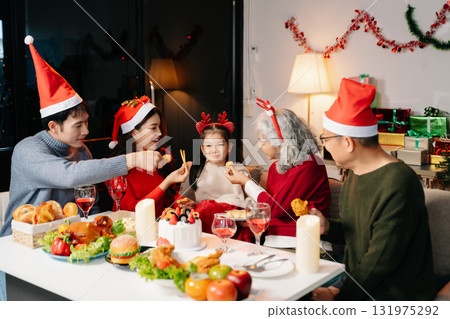 Celebrate Christmas with family in a cozy, festive setting. Santa hats, gifts, and delicious food capture the warmth, jo Celebrate Christmas with family in a cozy, festive setting. Santa hats, gifts, and delicious food capture the warmth, jo 131975292