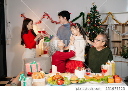 Celebrate Christmas with family in a cozy, festive setting filled with gifts, love, and joy. 131975523