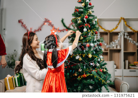 Celebrate Christmas with family in a cozy, festive setting filled with gifts, love, and joy. 131975621