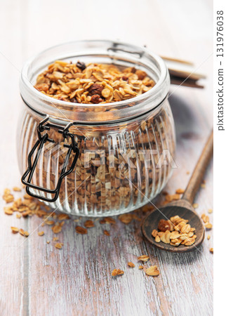 Granola breakfast cereal in glass jar with spoon Granola breakfast cereal in glass jar with spoon 131976038