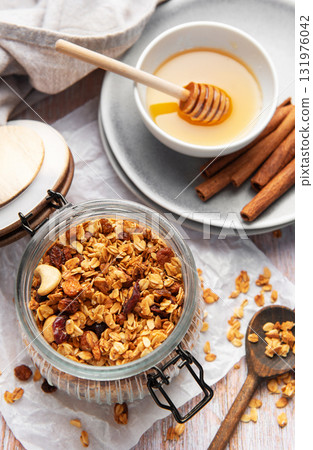 Granola in jar with honey and cinnamon Granola in jar with honey and cinnamon 131976042