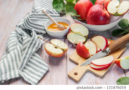 Sliced red apples and honey on wooden table Sliced red apples and honey on wooden table 131976059