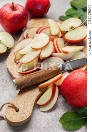 Red apples slicing on wooden cutting board Red apples slicing on wooden cutting board 131976062