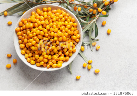 Sea buckthorn berries in bowl with branches Sea buckthorn berries in bowl with branches 131976063