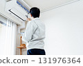 Male worker inspecting air conditioner 131976364