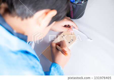 Boy writing a votive tablet for Shichi-Go-San 131976405