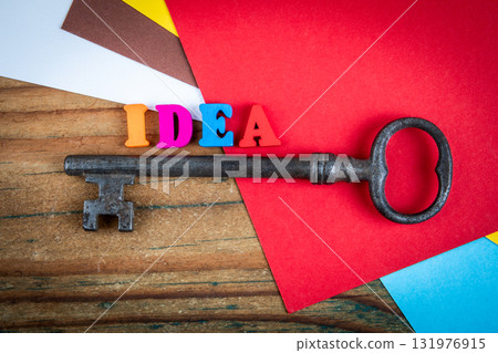 Idea concept with colorful wooden letters forming the word idea next to an old vintage key on bright 131976915