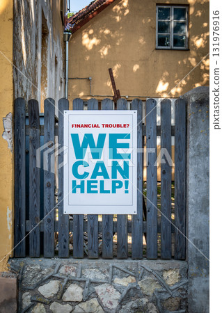 Financial help concept with outdoor sign on wooden fence reading financial trouble we can help 131976916