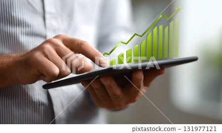 Man holding digital tablet with green upward chart 131977121