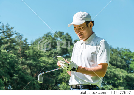 Male golfer using a smartphone on the golf course Male golfer using a smartphone on the golf course 131977607