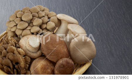 Various mushrooms in a colander on a black background Various mushrooms in a colander on a black background 131978901