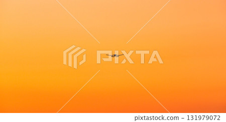 Orange evening sky and airplane 131979072