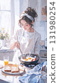 沐浴在柔和的晨光中，一位女士在廚房裡做飯 131980254