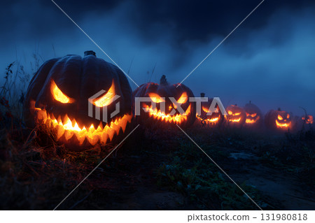 黑暗中一排令人毛骨悚然的南瓜燈。萬聖節夜景。 黑暗中一排令人毛骨悚然的南瓜燈。萬聖節夜景。 131980818