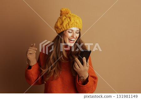 Joyful Woman Laughing with Smartphone and Finger Heart 131981149