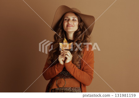 Serene Woman, Eyes Closed, Holding Fall Leaf 131981159