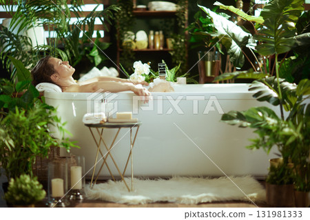 Woman Enjoying a Luxurious Bubble Bath Amidst Plants 131981333
