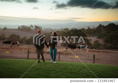 A Couple Enjoys a Delightful and Romantic Stroll on a Farm at Sunset A Couple Enjoys a Delightful and Romantic Stroll on a Farm at Sunset 131981467