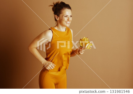 Cheerful Autumn Fitness: Woman with Yellow Leaves Cheerful Autumn Fitness: Woman with Yellow Leaves 131981546
