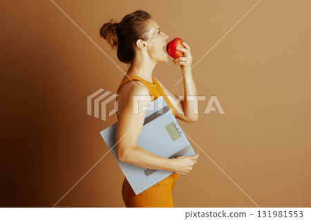 Mindful Eating: Woman with Apple and Scale Mindful Eating: Woman with Apple and Scale 131981553
