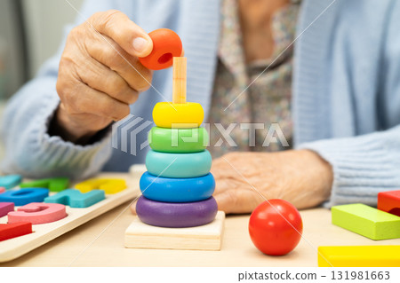 Alzheimer disease AD, Asian elderly woman patient suffering from dementia learn practical motor skills rehabilitation. 131981663