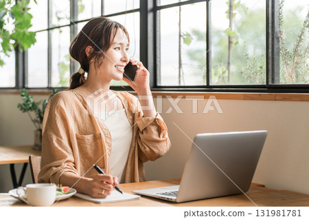 Young Asian woman teleworking/nomad working in a cafe Young Asian woman teleworking/nomad working in a cafe 131981781