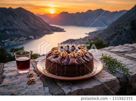 Montenegrin fig and walnut cake with red wine during a beautiful sunset over a mountain bay 131982355