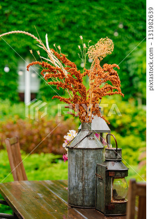 Bouquet of dried flowers in a vintage balloon on a wooden table in the garden. Bouquet of dried flowers in a vintage balloon on a wooden table in the garden. 131982639