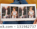 Female hands flipping through a photo book with wedding photos 131982737