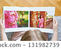 woman is holding and flipping through a photo book with a pregnancy photo shoot 131982739